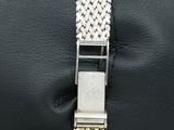 a close up of a silver bracelet on a black pillow