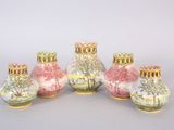 three vases with pink and yellow designs on them sitting next to each other