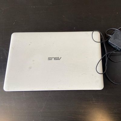 un ordinateur portable blanc posé sur une table à côté d'une souris