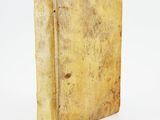 an old book sitting on top of a table on a white surface