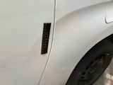 a close up of a white truck with a red sticker on it