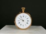 une petite horloge posée sur un bloc de marbre