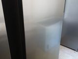 a silver refrigerator in a kitchen with a white tile floor