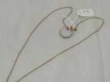 a gold necklace with a white tag on a white background