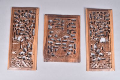 trois sculptures en bois accrochées au mur