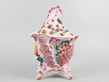 a white and pink vase with a bird on it