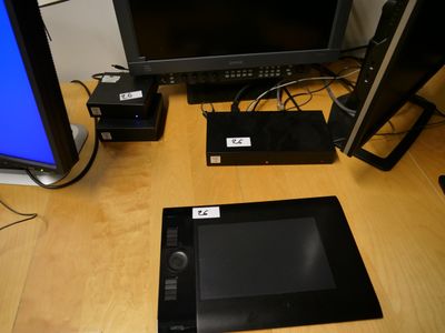 une tablette posée sur un bureau, à côté d'un écran