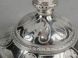 a silver plate with a decorative design on the top of it