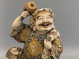 a figurine of a laughing man holding a phone