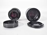 two lenses sitting next to each other on a white surface