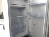 an open refrigerator with its door open on a tiled floor