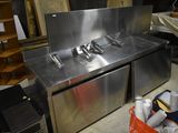 a stainless steel sink in the middle of a room
