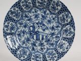 assiette bleue et blanche ornée d'un motif représentant des fleurs et un oiseau
