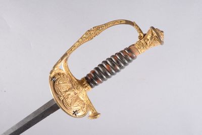 un gros plan d'une épée à la poignée dorée sur un fond blanc