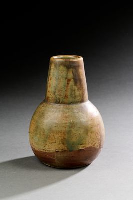un vase marron et vert posé sur une table