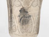 une tasse en argent antique avec un motif floral sur le bord