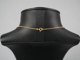 a black mannequin with a gold heart charm on it