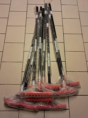 five different types of brooms on a tiled floor