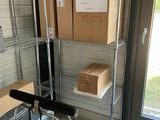 une étagère métallique sur laquelle sont posées des boîtes, dans une pièce