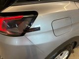 the rear end of a silver car in a showroom