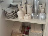 many plates and cups on the shelves in the kitchen