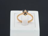 gros plan d'une bague en or avec des pierres bleues et blanches