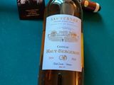 une bouteille de vin blanc et un cigare posés sur une table
