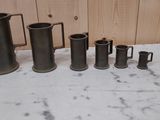 cinq vases de tailles différentes posés sur une table