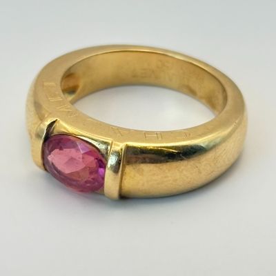 une image d'une bague en or avec une pierre rose au centre