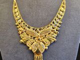 un collier en or exposé dans une vitrine