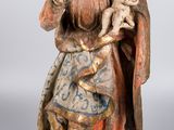 une vieille statue représentant une femme tenant un bébé dans ses bras et coiffée d'une couronne