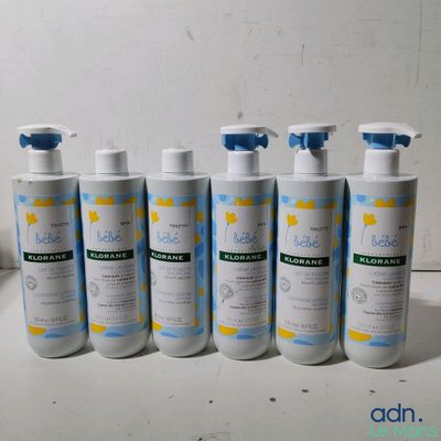 six bottles of baby lotion sitting on a counter top next to a bottle of lotion