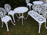 quatre chaises blanches et une table dans le jardin