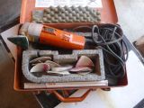 an orange case with tools inside of it on a table