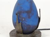 a blue egg shaped lamp on a stand with a black cord