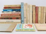 several books are stacked on top of each other on a white surface