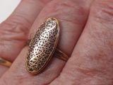 une personne tenant une bague en or dans la main