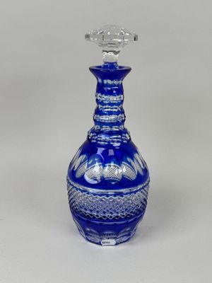 une image représentant une carafe en verre bleu sur fond blanc