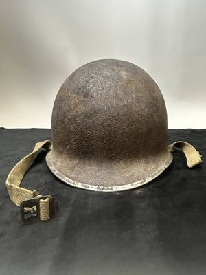 an old helmet is sitting on top of a black cloth