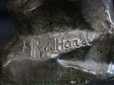 a bronze statue of a dog with a name on it