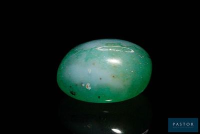 an image of a green jade stone sitting on top of a black surface