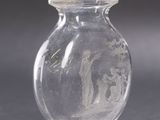 a clear glass vase sitting on top of a table next to a shadow