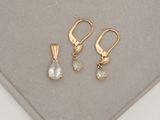 two pairs of earrings and a pendant on a white surface