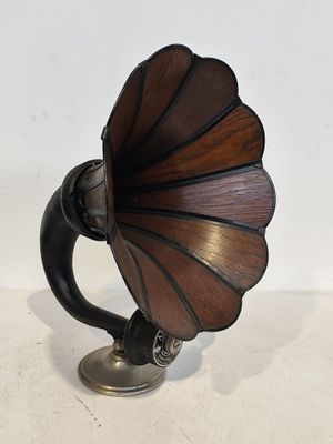 un vieux gramophone posé sur un support, sur une surface blanche