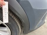 a hand that is holding a sticker near a car