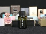 several bottles of perfume are lined up on a black table