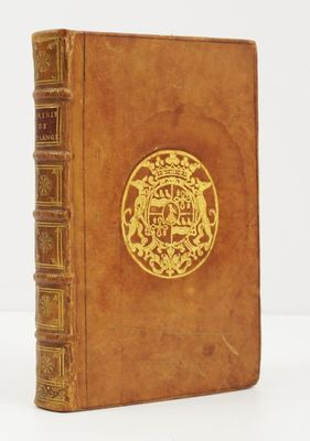 un vieux livre avec un emblème en or sur la couverture