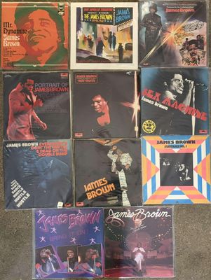 various vinyl records are on the floor in front of a wall
