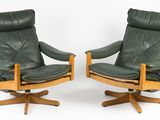 paire de fauteuils pivotants en cuir vert, avec des pieds et des accoudoirs en bois