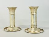 two silver candlesticks that are sitting on a table